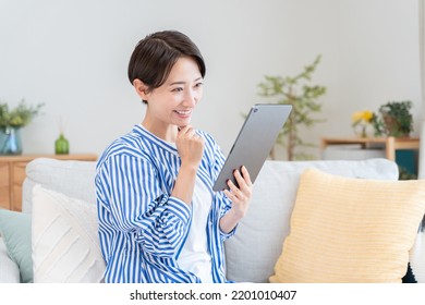 Asian Woman Looking At Tablet PC