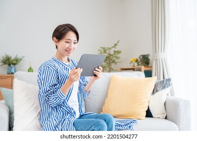 Asian Woman Looking At Tablet PC