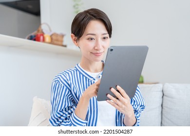 Asian Woman Looking At Tablet PC