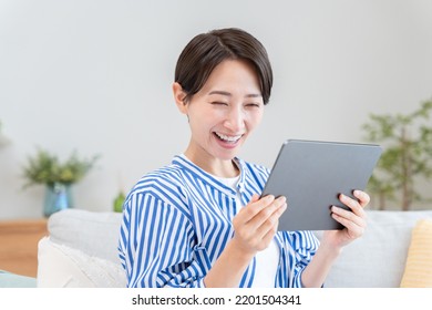 Asian Woman Looking At Tablet PC