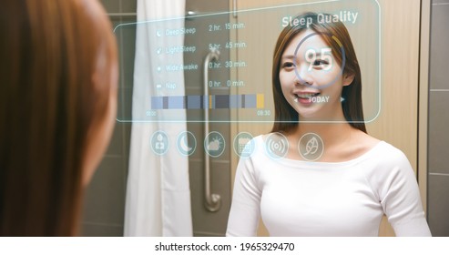 Asian Woman Looking And Touching Smart Screen At Bathroom While Waking Up - Using Health App Analyzing The Sleep From A Tracker And Showing The Data.