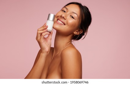 Asian Woman Loving The New Beauty Care Product. Female Model Holding A Cosmetic Product.