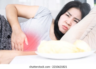 Asian Woman Lying Down After Eating Cause Discomfort, Indigestion With Stomach Acid Or GERD  