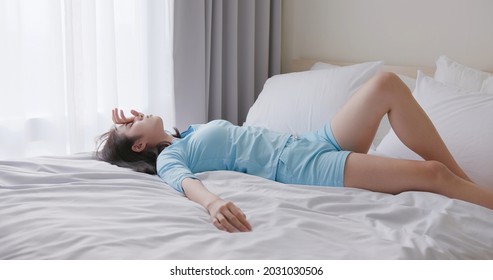 Asian Woman Lying On Bed And Streching Hands In Room