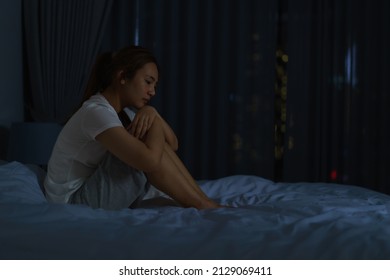 Asian Woman Lying On A White Bed In The Bedroom Looking Worried Or Thinking About Something About Her Life Or Work In Mid Night At Home.