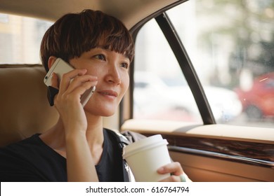 Asian Woman Making A Phone Call In Cab