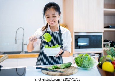 Asian Woman Making Salad In Kitchen. Healthy Eating Lifestyle Concept.