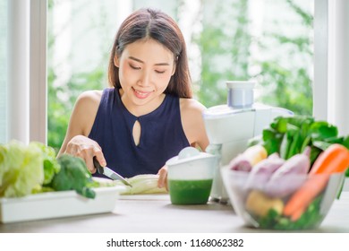 Asian woman making smoothie with fresh vegetables in the blender in kitchen at home. Green healthy food concept. - Shutterstock ID 1168062382