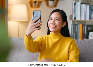 Asian Woman Making Video Call Via Mobile Phone Talking With Friends