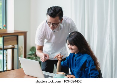 Asian Woman And Man Discussing Work Using On Laptop Computer At Cafe Co Working Space ,Digital Age Lifestyle,Working Outside Office Concept