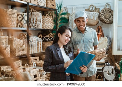 Asian Woman And Man List Items Among The Handicraft Items In The Craft Gallery