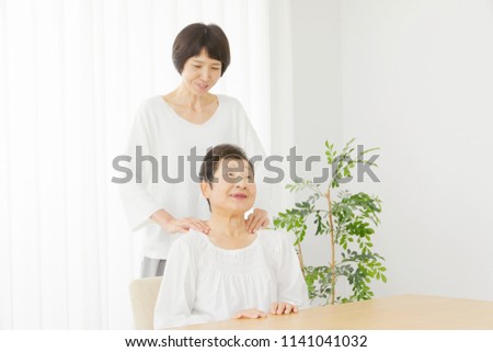 Asian Woman Massages The Senior Citizens Shoulders Asian Woman Massages The Senior Citizens Shoulders