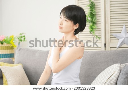 Asian woman massaging the chest in the living room