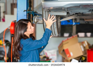 Asian Woman Mechanic Is Looking At The Tire To Check The Condition For Change New One.