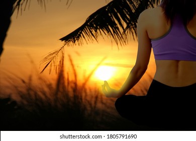 Asian Woman  Is Meditating In Lotus Position With Sun Rise Beauty Sky