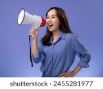 asian woman with megaphone, blue blouse, making an announcement on a vibrant purple background