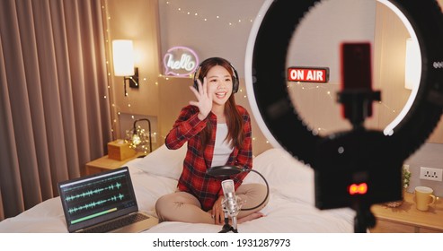 Asian Woman With Microphone Has Live Stream And Singing Through Smartphone In Bedroom At Home