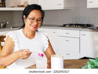 Asian Woman Mid Age On Diet Preparing Breakfast Drink High Protein Replace Meal. Woman Making Vegan Liquid Meal From Plant Base Protein Pea Protein Powder In The Kitchen. 