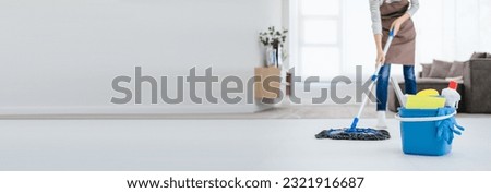 Asian woman mopping tile floor at living room while doing cleaning at home during Staying at home using free time about their daily housekeeping routine.