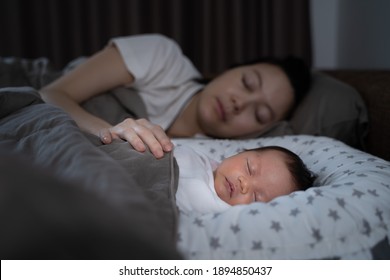 asiatische Frau Mutter und Baby schlafen im Bett. Kleinkinder können nachts ohne Probleme schlafen. Konzept des erschöpften Muttersyndroms. 