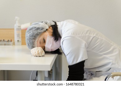 Asian Woman Nurse Sleeping Tired At Table In Clinic