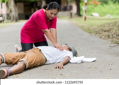 Asian Woman Or Nurse Or Specialist First Aid Emergency CPR On Heart Attack Senior Man Senior Man With Cardiac Arrest While Jogging Or Exercise On Park. Basic Help Or Basic Life Support ,People Concept