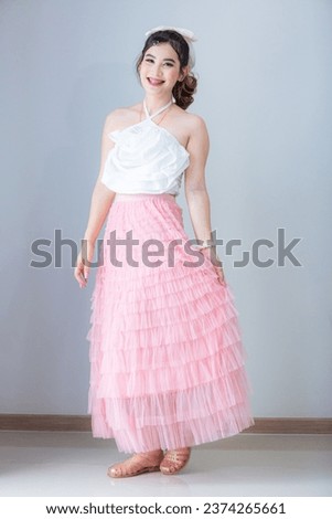 Asian woman on the background,Photo of young Asian girl on pink background,Asian woman wearing a skirt on a background