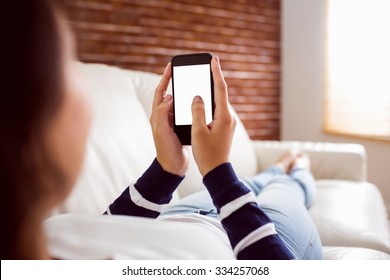 Asian Woman On The Couch Using Phone At Home In The Living Room