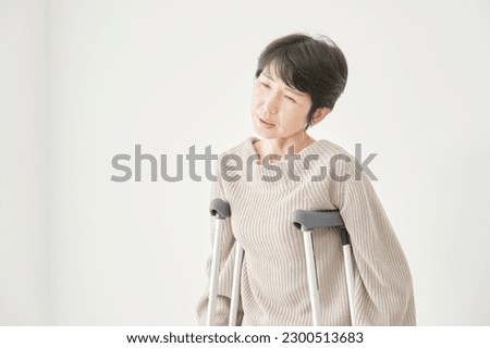 Asian woman on crutches in trouble in white background