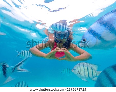 Asian woman on a snorkeling trip at Samaesan Thailand. dive underwater with Nemo fishes in the coral reef sea pool. Travel lifestyle, watersport adventure, swim activity on a summer beach holiday 