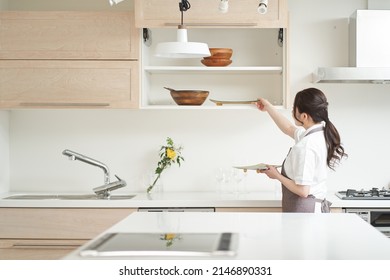 Asian Woman Organizing The Kitchen