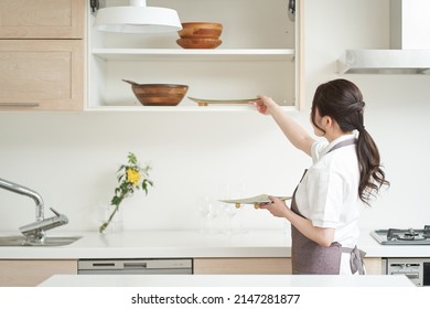 Asian woman organizing the kitchen
