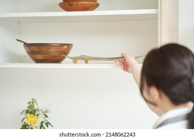 Asian Woman Organizing The Kitchen