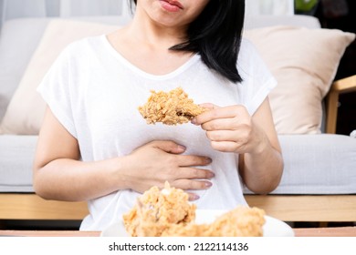 Asian Woman Overeating Fried Chicken Have A Stomachache, Indigestion Because Of Eating Too Much, Or Binge Eating Disorder