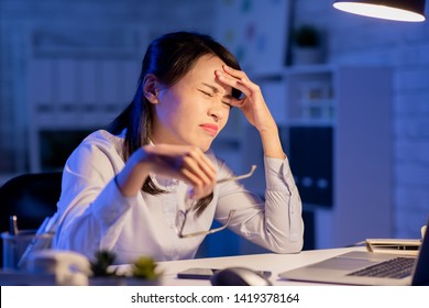 Asian Woman Overtime Work And Feel Headache In The Office