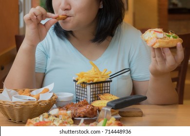 Asian Woman Is Overweight From High Calories Foods,fat Female Enjoy Eating Snack And Hold Pizza In Hand