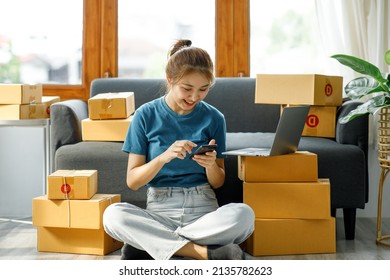 Asian woman owned business SME entrepreneur of Young Asian women working with Boxs laptop and phone for Online seller shopping at home, online marketing packaging delivery SME e-commerce concept