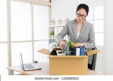 Asian Woman Packing And Cleaning Her Office Since She Is Going Tho Leave The Company And Resign.