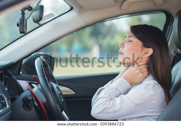 Asian woman\
with pain at her neck after\
driving