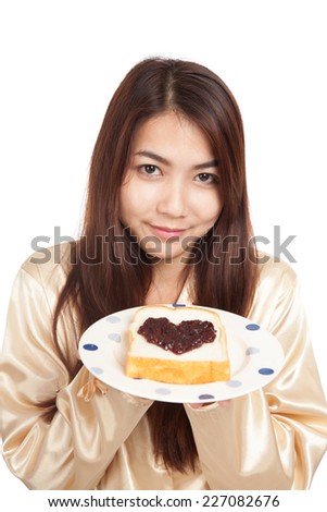 Asian woman in pajamas with bread and heart shape berry jam  isolated on white background