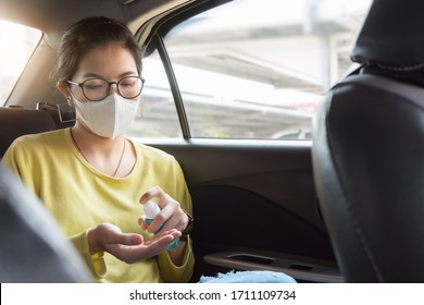 Asian Woman Passenger In Green Shirt Wear Surgical Mask And Glasses Spraying Hand Sanitizer Alcohol On Her Hands For Cleaning And Prevent Covid-19 Or Coronavirus While Sitting In A Car. Health Care