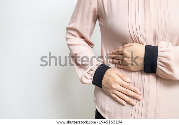 Asian woman patient with abdominal pain on right\
side belly,painful in abdomen,irritable bowel disease,lady girl\
holds under the ribs,stomach ache,cirrhosis of the liver\
disease,liver cancer\
concept