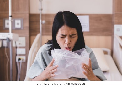 Asian woman patient puke or vomiting into plastic bag at hospital,Nausea,Indigestible