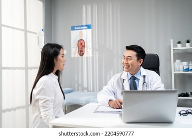 Asian woman patient visit and consult health problem with young doctor. Attractive therapist practitioner work to explain diagnosis in office hospital to give treatment to sick girl during appointmen