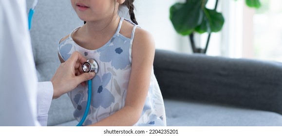 Asian woman pediatrician doctor hold stethoscope for exam a little girl patient and heck heart lungs of kid, Good family doctor visiting child at home, Healthcare and medicine for childhood concept. - Powered by Shutterstock