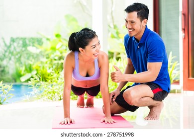 Asian Woman And Personal Trainer At Sport Exercise Doing Push-ups