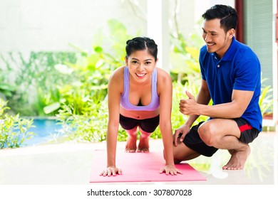 Asian Woman And Personal Trainer At Sport Exercise Doing Push-ups