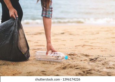 Asian Woman Picking  Bottle Into Plastic Bag Black For Cleaning The Beach In Morning Time, Volunteer Concept.