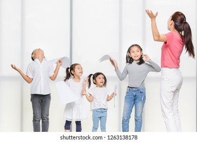 Asian woman in pink shirt teach Asian girls and boy utter, they stand in front of big white window. Concept for acting class for kids and young.
