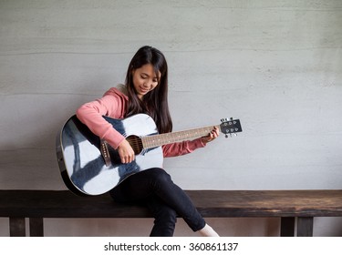 Asian Woman Play With Guitar At Home